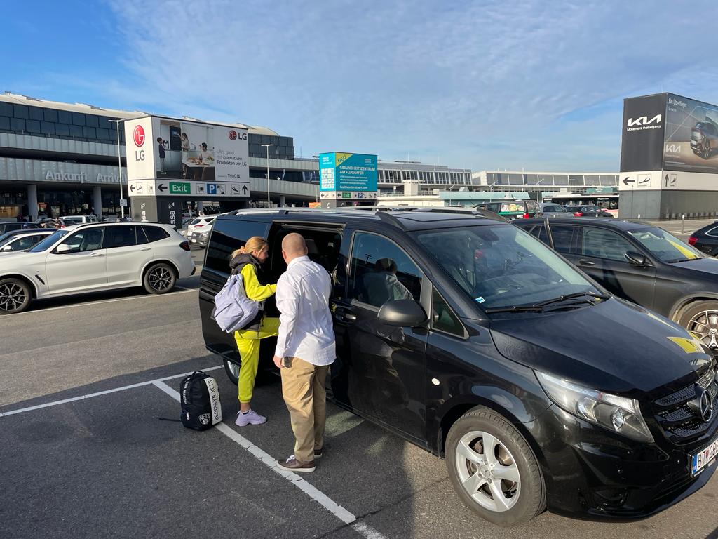 Driver helping passengers with luggage